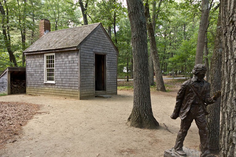 Henry David Thoreau'nun Walden Gölü yakınlarında yaşadığı kabinin replikası ve önündeki heykeli