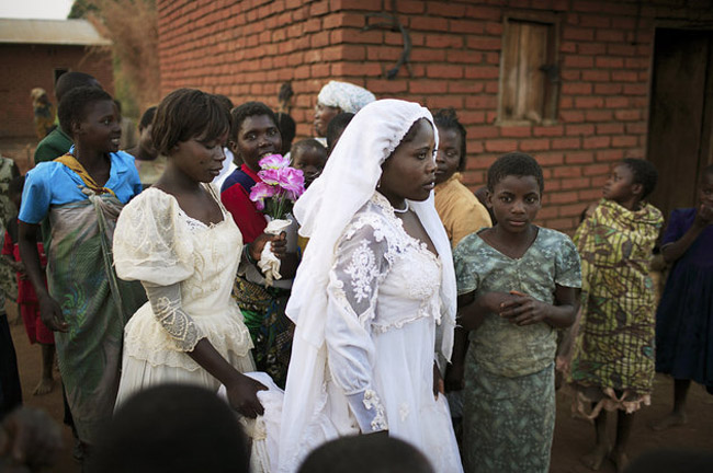 Malavi’nin fakir köylerinden birinde 16 yaşındaki Suzana Nabanda ve kız kardeşi evlilik töreni sırasında birlikte yürürken… Suzana az önce bir çiftçiyle evlendirildi. (2006) – fotoğraf: Per-Anders Petterson